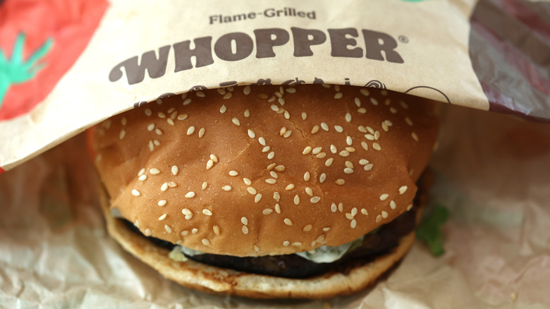 Burger King Whopper in a half-opened paper wrapper