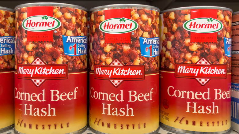 Several cans of Mary Kitchen Corned Beef Hash stacked on a store shelf