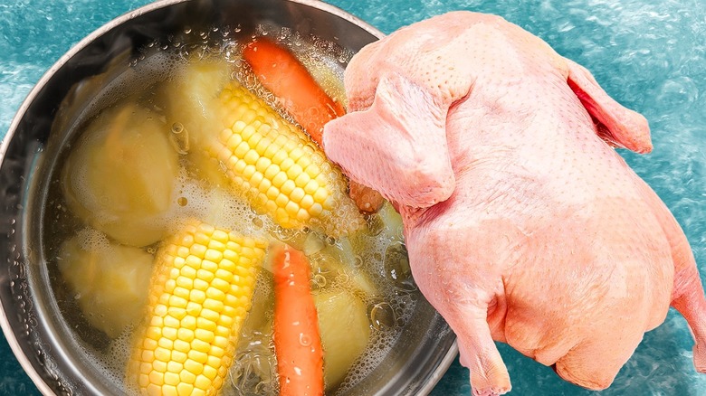 Chicken and boiling pan of vegetables