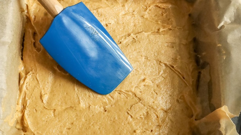 Spatula smoothing cake batter into pan