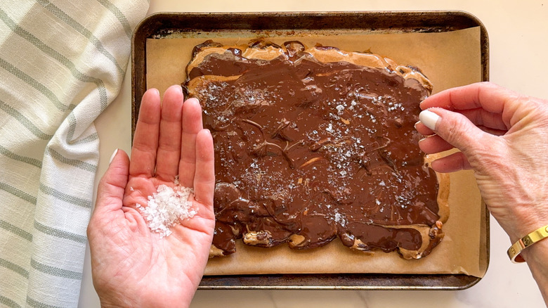 hand adding salt to bark