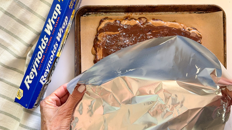 hand adding foil to bark