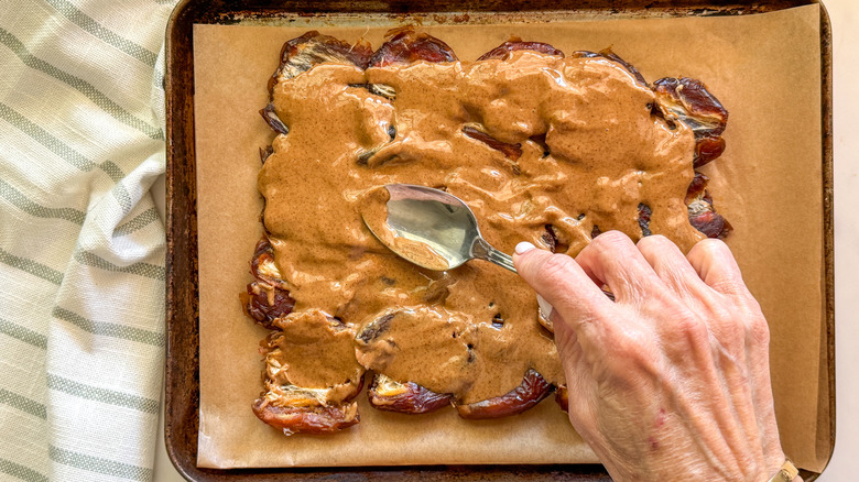 hand spreading peanut butter
