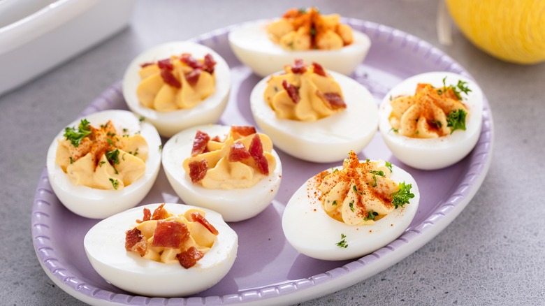 Tray of deviled eggs with seasonings and jerky
