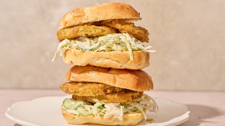 A fried green tomato sandwiches with coleslaw on a plate