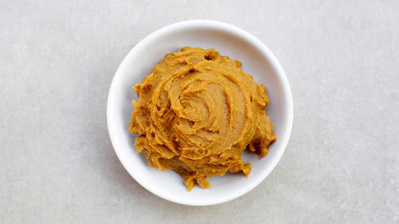 A bowl of miso paste on a gray background