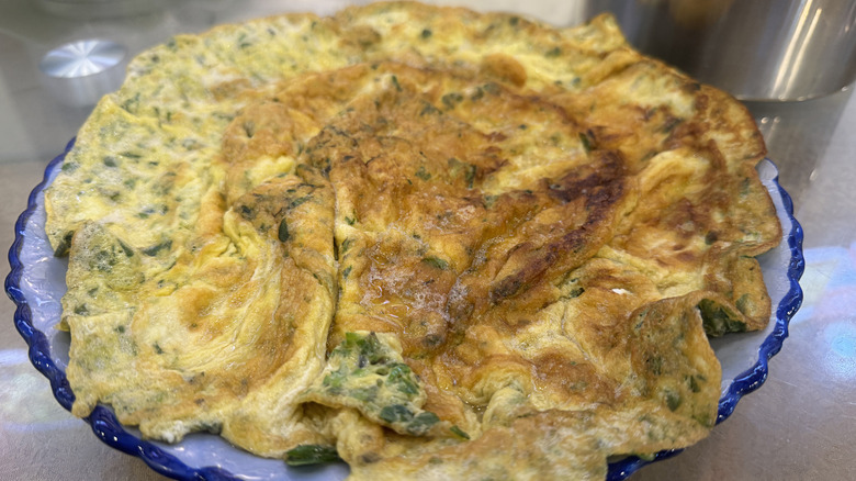 a scallion omelet overflowing off a plate