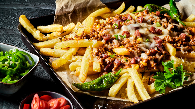 chili cheese fries on tray with peppers on side