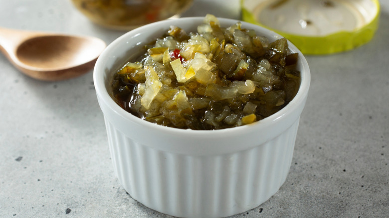Close-up of dill pickle relish in a small white ceramic dish