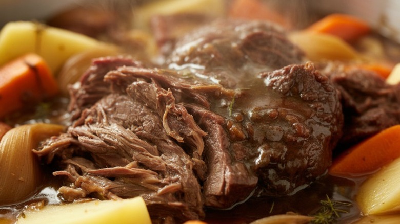 A juicy looking pot roast nestled among vegetables