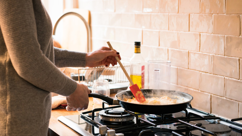 A woman stirring scrambled eggs