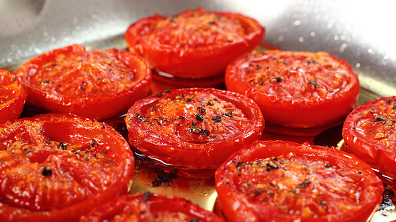 Rows of grilled tomato slices in metallic pan