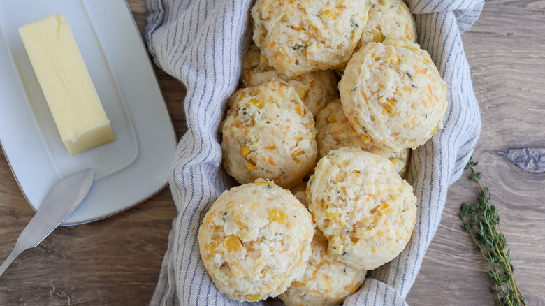 Sweet corn biscuits in basket next to butter 