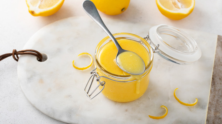 A jar of lemon curd on top of a marble serving platter