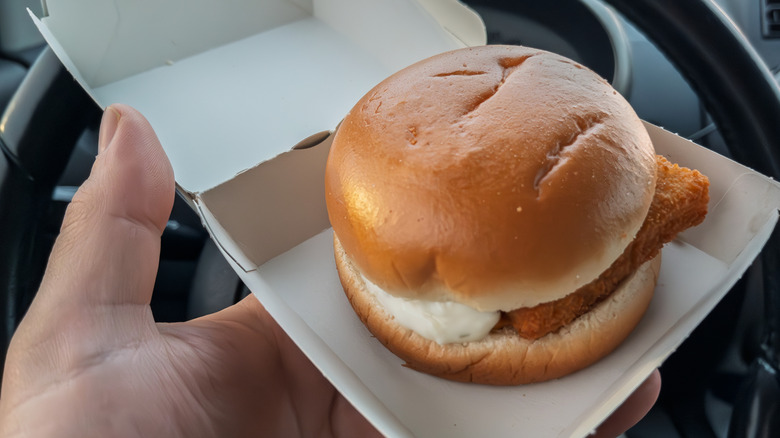A closeup of a Filet-O-Fish sandwich inside a car