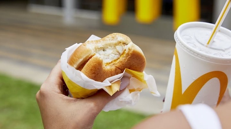 Person holding a Filet-O-Fish and drink from McDonald's