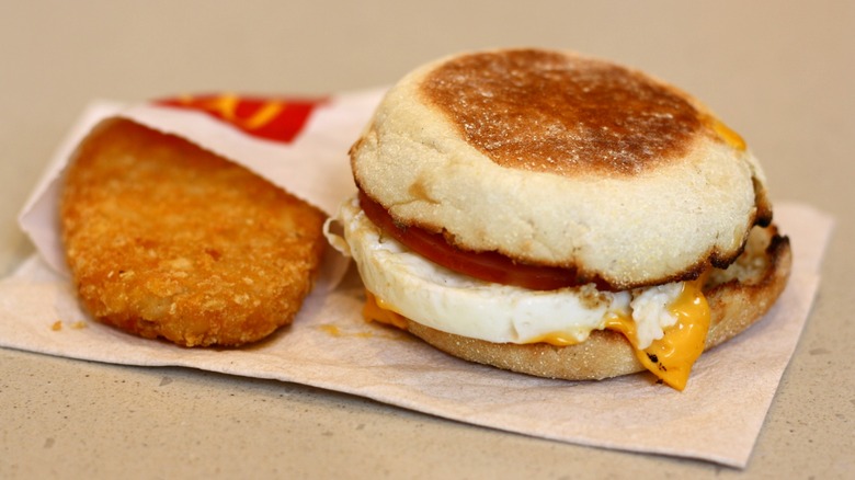 McDonald's Egg McMuffin and hash brown sitting on light brown paper napkin