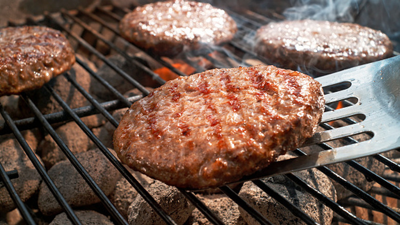 close up of burgers cooking on the grill