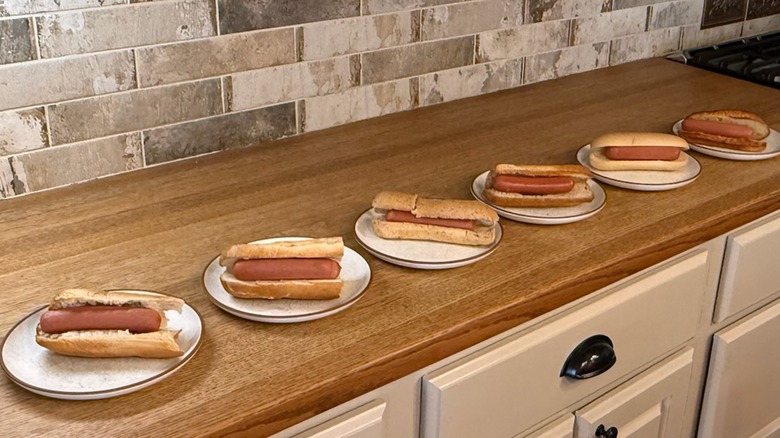 hot dogs in gluten-free buns lined up on plates