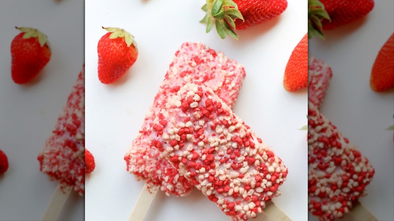 Good Humor Strawberry Shortcake Bars with strawberries on white surface.