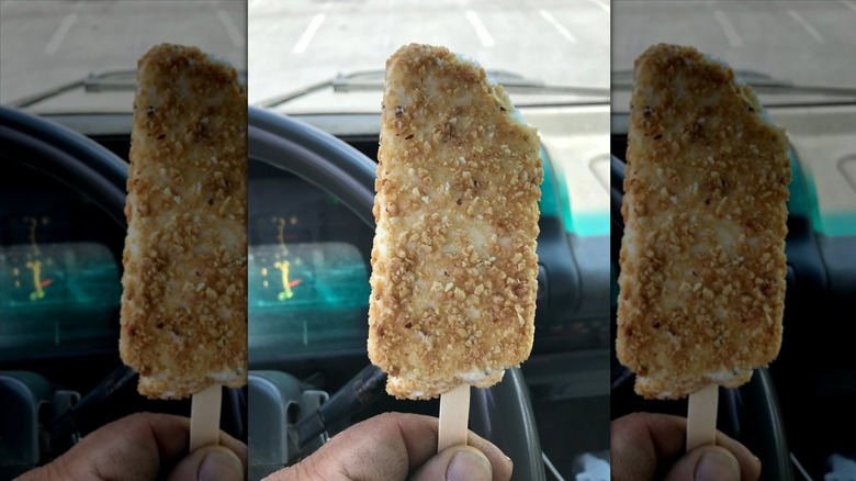 Hand holding Toasted Almond Bar in car.