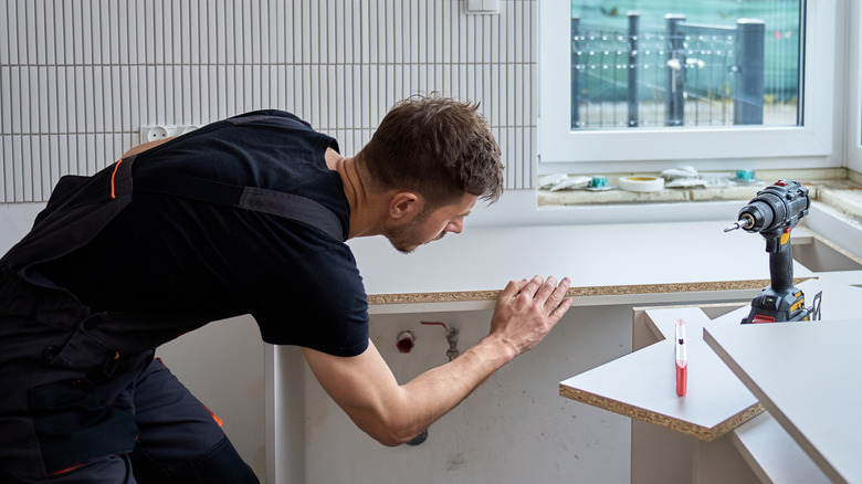 Someone installing a kitchen countertop