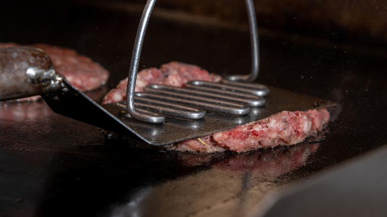 hamburger patty being smashed by spatula