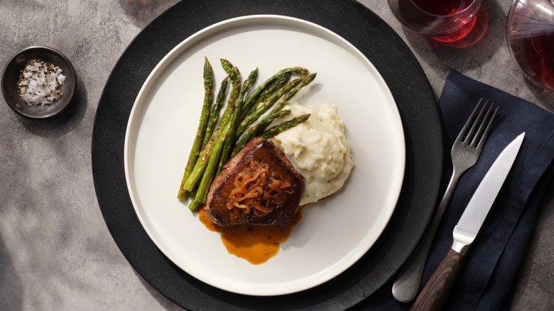 Home Chef and Gordon Ramsay's French Onion Filet Mignon with mashed potatoes and asparagus on a white plate