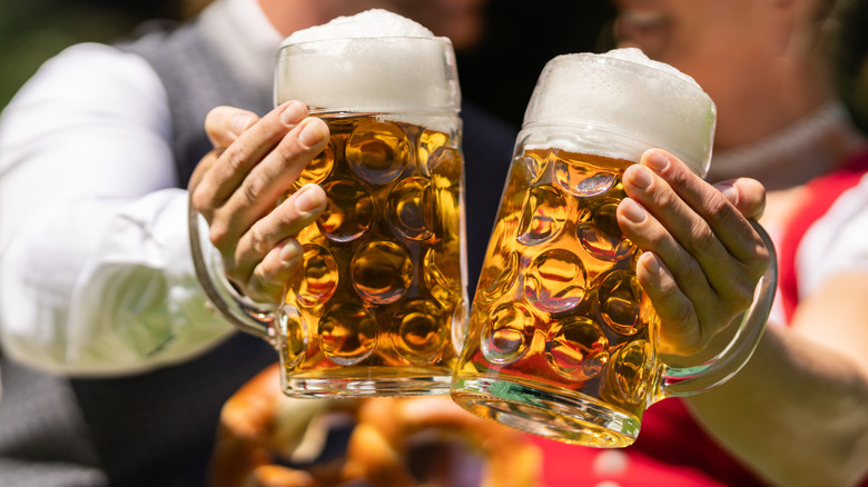 people dressed in historic attire toasting with beer mugs