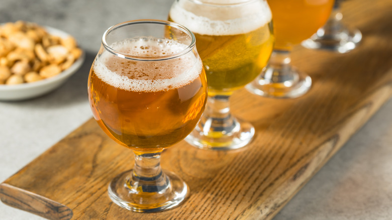 a flight of beer on a wooden board