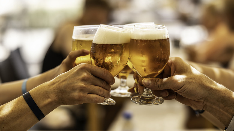 four people toasting with beer