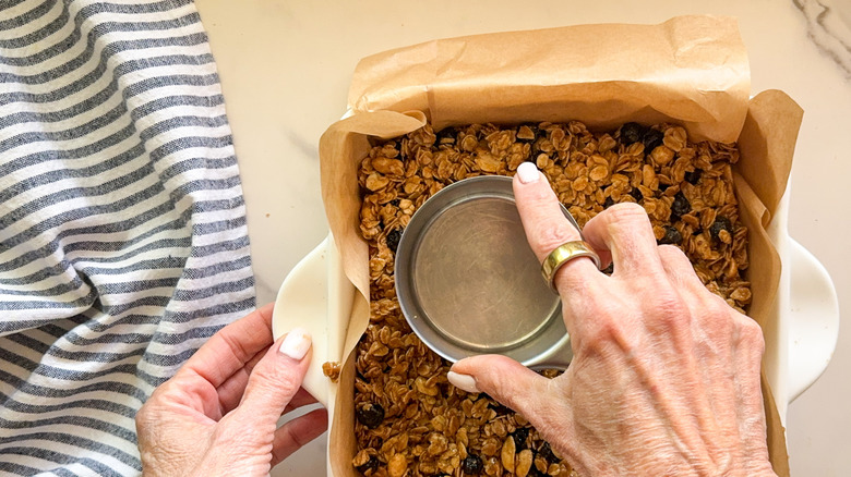 hand pressing cup into bar mixture