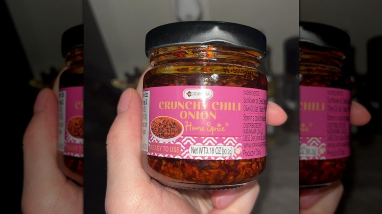 A person holding a jar of Katayama Crunchy Chili Onion Home Spice