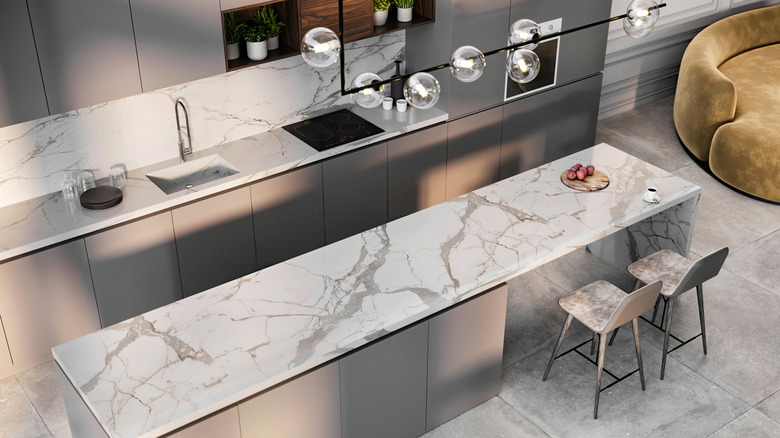 A white and grey marble kitchen island, viewed from above, in a modern-looking kitchen