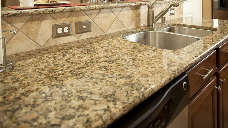A Granite kitchen countertop with a stainless steel sink.