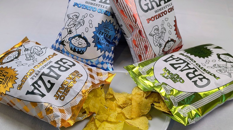 Two open bags of Graza chips spilling onto a plate with two closed bags behind them