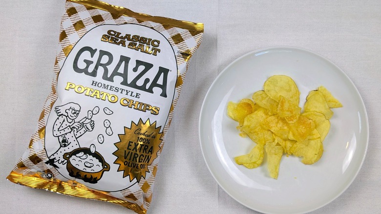 A bag of Graza Classic Sea Salt potato chips and a white plate of chips on a white tablecloth