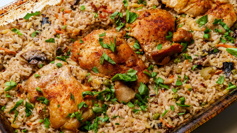 garlic butter chicken on tray with rice and herbs