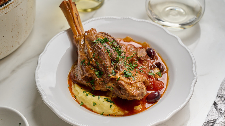 lamb shank in a bowl with mashed potatoes