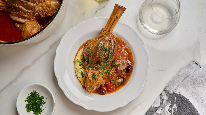lamb shank on a plate with mashed potato