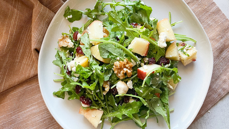 Arugula, apple, and walnut salad on plate