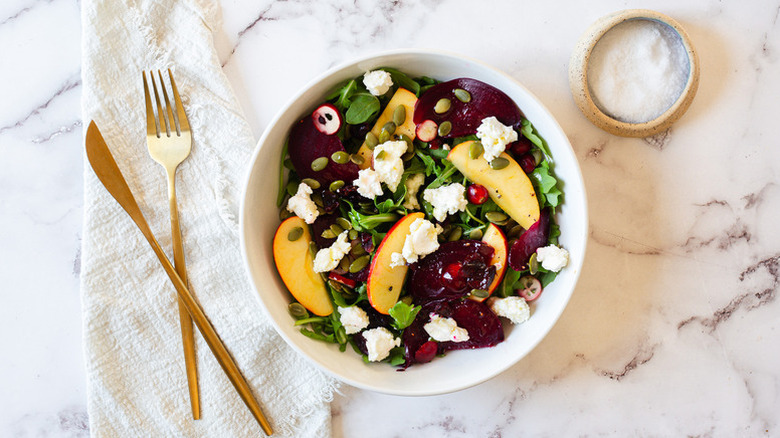 Beet, apple, and feta salad in white bowl