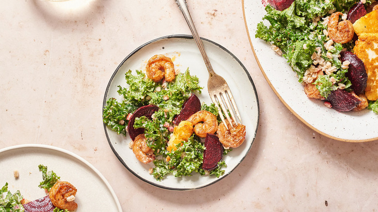 Shrimp, beet, and kale salad served onto plate