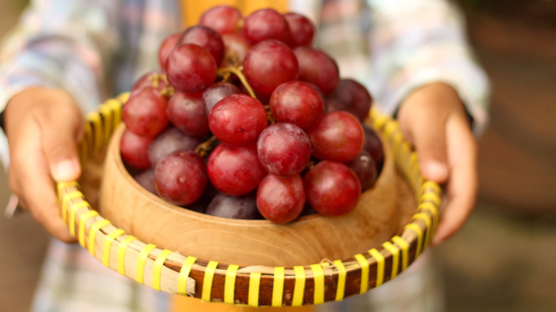 Woman holding red grapes