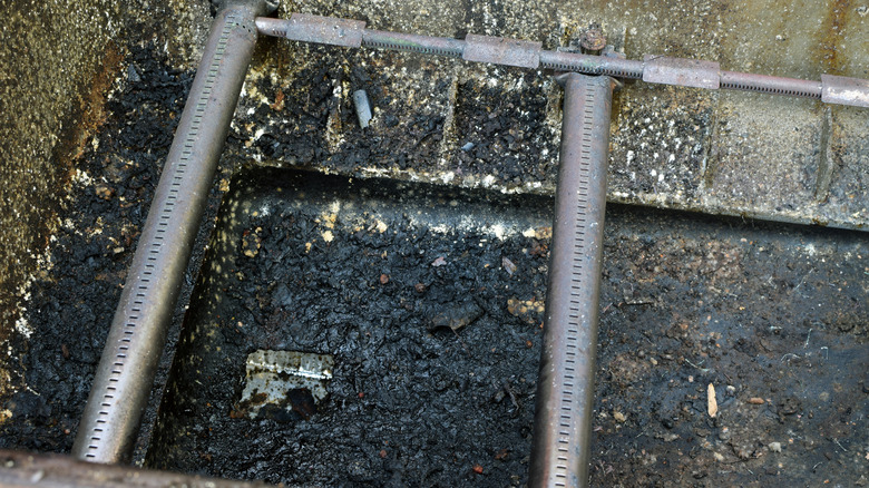 Close-up of dirty burner tubes installed in a gas grill
