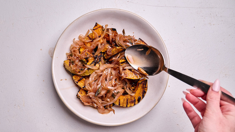 spooning agrodolce over squash in a bowl