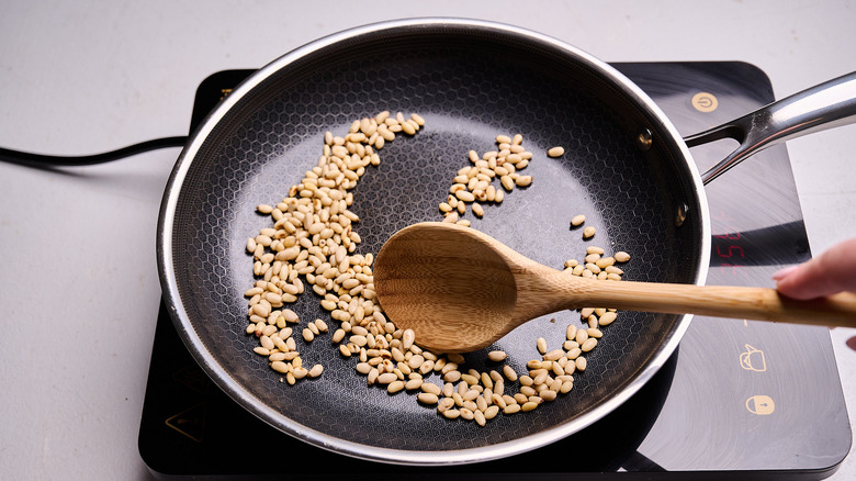 toasting pine nuts in a skillet