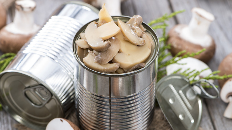 An open tin can filled with sliced mushrooms.