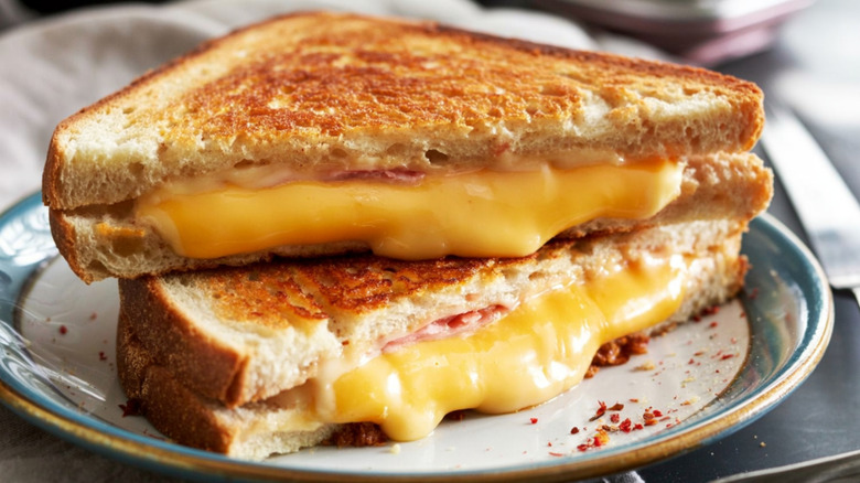 Two triangle halves of grilled cheese, with the cheese oozing out.