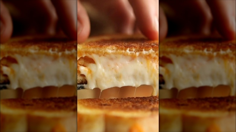 Lifting slice of grilled cheese sandwich with cream cheese